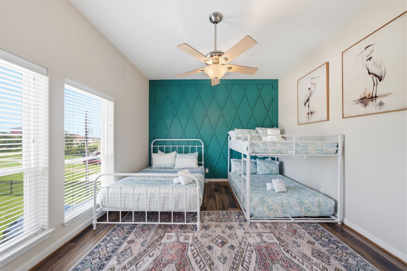 This bedroom has a queen-sized bed and a full over full bunk bed