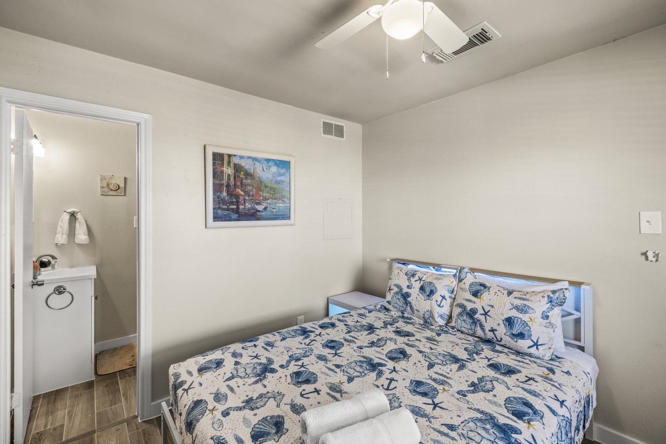 This bedroom features a plush queen bed with a private ensuite