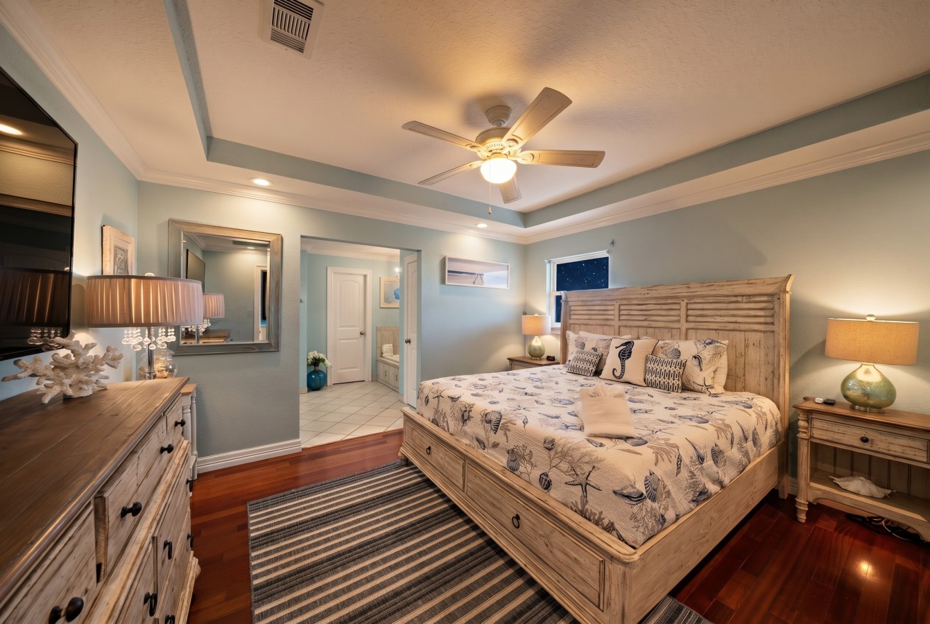 Relax in this spacious primary bedroom with coastal charm