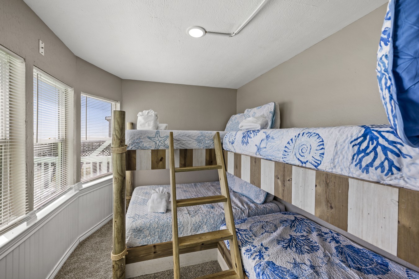 This bedroom has 1 queen over queen bunk bed and 1 twin over twin bunk bed