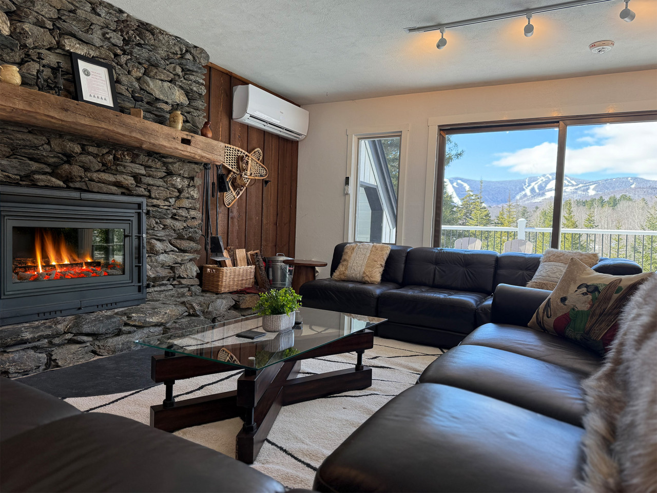 A cozy living room with a fireplace and a view of the mountains.