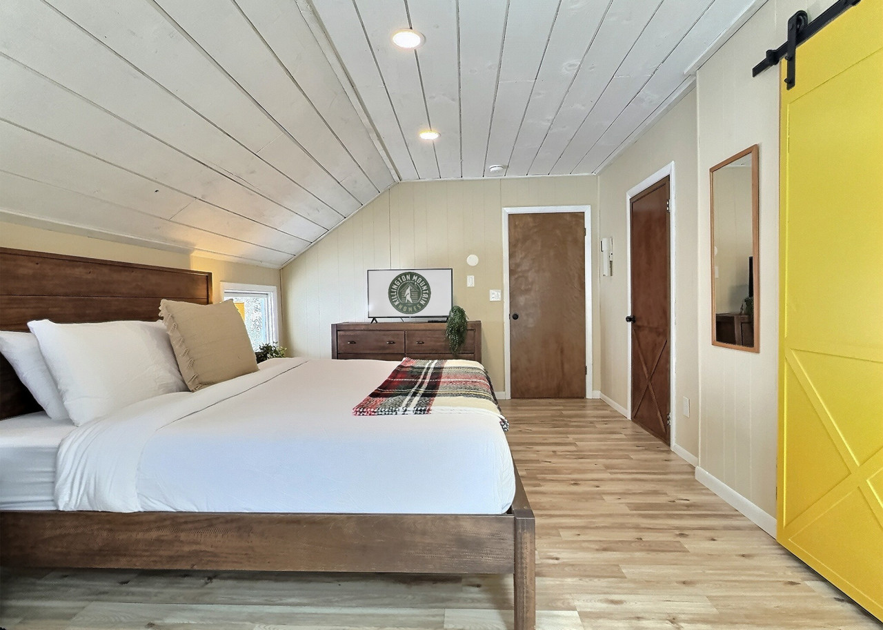 Spacious bedroom with a king bed and TV.