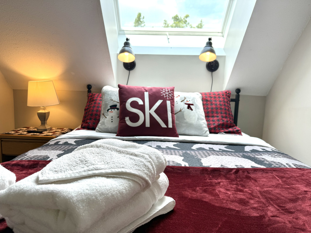 Bedroom with skylight and red bedding